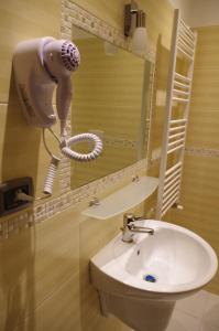 Un baño con un secador de pelo en la pared junto a un lavabo. en Hotel V7, en Milán