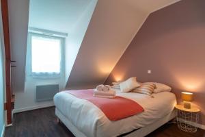 een slaapkamer met een bed met twee handdoeken erop bij Ty Kordenn - Proche Plage in Sarzeau