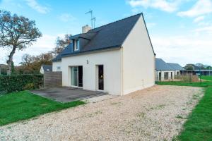 een wit huis met een veranda en een tuin bij Ty Kordenn - Proche Plage in Sarzeau +7 foto's