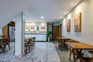 a dining room with tables and chairs and a kitchen at OYO Hotel Brisa Tropical, Brasília in Brasilia +37 photos