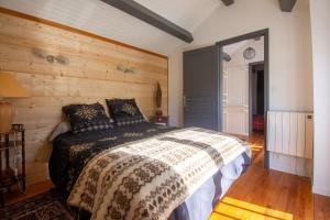 SorgeatLa Bergère - Proche Ax‑les‑Thermes的带床和木墙的卧室
