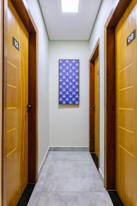 a hallway with two doors and a painting on the wall at OYO Hotel Brisa Tropical, Brasília in Brasilia