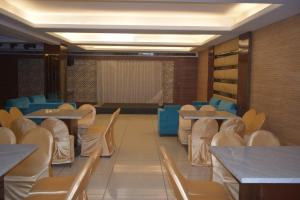 un comedor con mesas y sillas y una sala con en Hotel Candy Prime, en Chandigarh Airport
