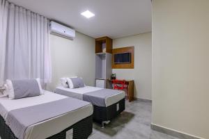 a hospital room with two beds and a tv at OYO Hotel Brisa Tropical, Brasília in Brasília