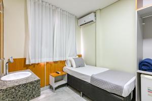 a small bedroom with a bed and a sink at OYO Hotel Brisa Tropical, Brasília in Brasília +37 photos