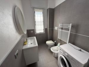 a bathroom with a toilet sink and a washing machine at Appartamenti Rugacesio 24 - B in Pioltello