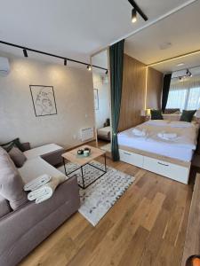 a living room with a couch and a bed at Apartmani Balkan Square in Zlatibor