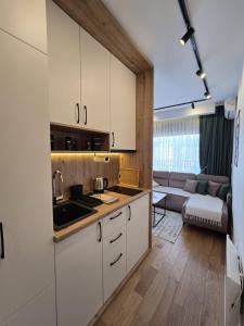 ズラティボールにあるApartmani Balkan Squareの白いキャビネット付きのキッチン、リビングルーム