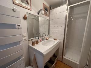 ein weißes Badezimmer mit Waschbecken und Dusche in der Unterkunft Appartement esprit montagne in Le Lioran + 35 Fotos