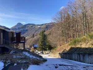 eine schneebedeckte Straße mit einem Berg im Hintergrund in der Unterkunft Appartement esprit montagne in Le Lioran