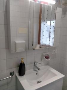 une salle de bain blanche avec un lavabo et un miroir dans l'établissement Monolocale policlinico gb rossi borgo roma verona, à Vérone