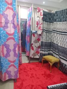 pokój z czerwonym dywanem i zasłonami oraz czerwonym dywanem w obiekcie سكن مختلط شهري بنات اولاد w mieście Adżman