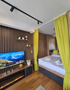 ズラティボールにあるApartmani Balkan Squareのベッドルーム(ベッド1台、テレビ、暖炉付) +24枚の写真
