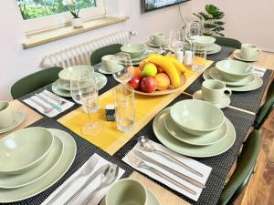 une table avec des plats blancs et des fruits dessus dans l'établissement Complete All Inclusive Apartment+Netflix, à Wilhelmshaven 20 autres photos
