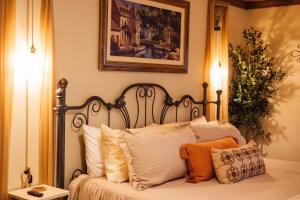 a bed with white pillows and a picture on the wall at Escape to Villa Serena in Dahlonega +67 photos