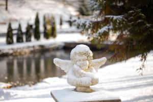 a statue of a little angel in the snow at Voevodyno Resort in Tur'ya Pasika