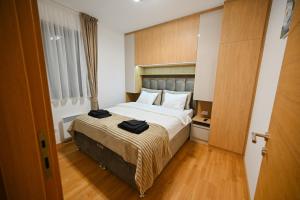 a hotel room with a bed with black towels on it at Monte Royal Zlatibor in Zlatibor