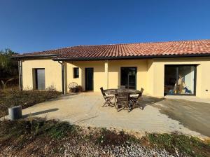 a table and chairs in front of a house at Viviloue in Saint-Pierre-Lafeuille