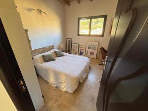 圣皮尔拉菲Viviloue的卧室里有一张铺着白色床单的床和一扇窗户