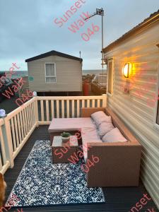 a patio with a couch and a table on a balcony at Sunset Walk 046 in Barmouth