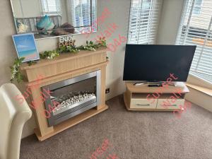 a living room with a fireplace and a television at Sunset Walk 046 in Barmouth