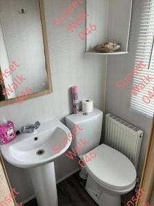 a bathroom with a sink and a toilet and a mirror at Sunset Walk 046 in Barmouth +2 photos