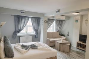 a bedroom with a bed and a living room at Jeweller Hotel in Ruse