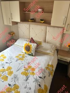 a bedroom with a bed with a sunflower comforter at Sunset Walk 046 in Barmouth