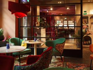 ein Restaurant mit Tischen und Stühlen in einem Raum in der Unterkunft 25hours Hotel The Goldman in Frankfurt am Main