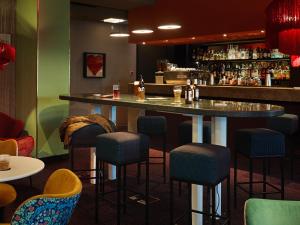 Eine Bar in einem Restaurant mit blauen Barhockern in der Unterkunft 25hours Hotel The Goldman in Frankfurt am Main + 31 Fotos