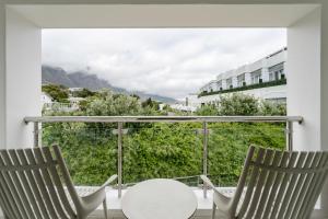 two chairs and a table on a balcony with a view at The Bay Hotel in Cape Town