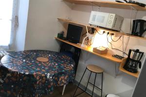 a small room with a table and a microwave at L'Idéal en Charteuse in Saint-Pierre-de-Chartreuse