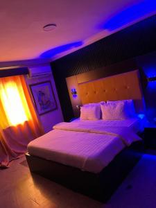 Festac TownにあるHotel Paris Suitesのベッドルーム(紫色の照明付きの大型ベッド1台付) +20枚の写真