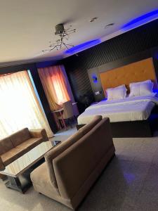 Festac TownにあるHotel Paris Suitesの大きなベッドとソファのある広い寝室