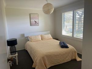 una camera da letto con un letto, una lampada e una finestra di Hillview Farm - Where the Country meets the Sea! a Yatte Yattah