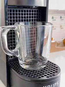 Ein Glasbecher steht auf einer Mikrowelle. in der Unterkunft Le New Daily, 500m du centre de Dax in Dax