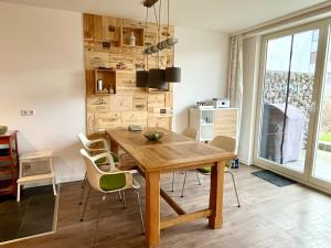 une salle à manger avec une table et des chaises en bois dans l'établissement Küstenliebe, à Heiligenhafen