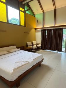 1 dormitorio con 1 cama, sillas y ventanas en Sibees Garden, en Kattappana