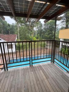 una terraza de madera con vistas a un patio en Sibees Garden, en Kattappana