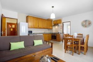 ein Wohnzimmer und eine Küche mit einer Couch und einem Tisch in der Unterkunft Campo Mar - T1 vista praia in São Martinho do Porto