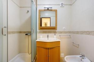 ein Badezimmer mit Waschbecken, Spiegel und Badewanne in der Unterkunft Campo Mar - T1 vista praia in São Martinho do Porto + 12 Fotos