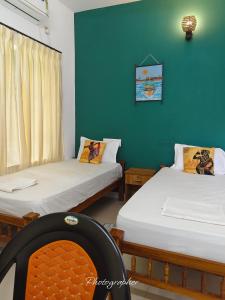 瓦尔卡拉Pachamama Home Stay的一间设有两张床和绿色墙壁的客房