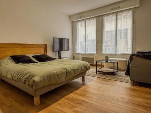 沙特尔Studio idéalement situé cathédrale et centre-ville的卧室配有床、桌子和窗户。