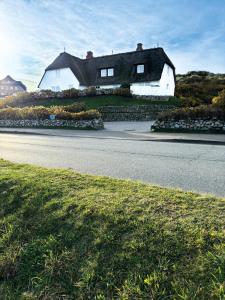 a house sitting on the side of a road at Wattblick Haus Wattblick "Wattglück" in Rantum +7 photos