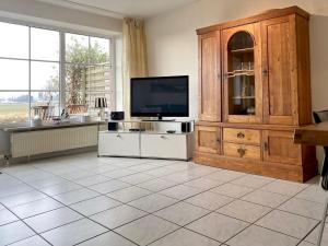 a living room with a television and a cabinet at NTBM36002-FeWo-Kiekut in Neue Tiefe Fehmarn