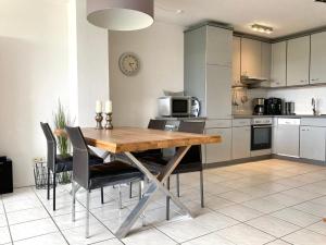 a kitchen with a wooden table and chairs at NTBM36002-FeWo-Kiekut in Neue Tiefe Fehmarn