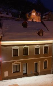 a building with several windows at night at Apartmany Pod Kloboukem in Jáchymov