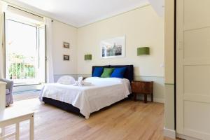 ローマにあるBright and Comfy 3 bedroom apt in Montiのベッドルーム1室(青と緑の枕が備わるベッド1台付)
