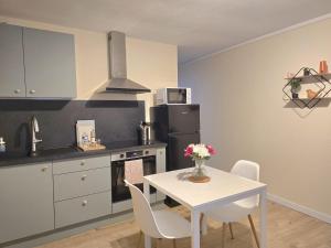 a kitchen with a table and a white table and chairs at Charmant T2- Besançon hyper centre in Besançon