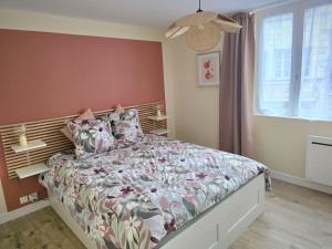 a bedroom with a bed with a floral bedspread at Charmant T2- Besançon hyper centre in Besançon +4 photos